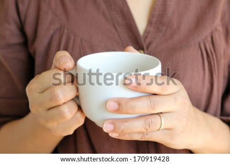 white hot coffee cup in woman hand.