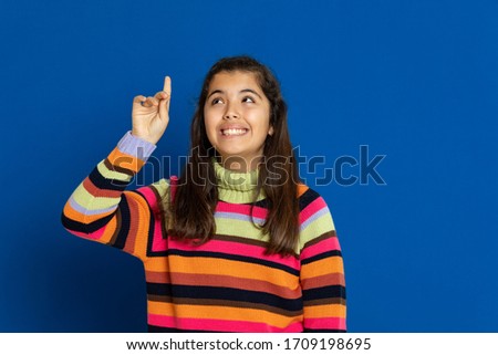 Adorable preteen girl with striped jersey on a blue background