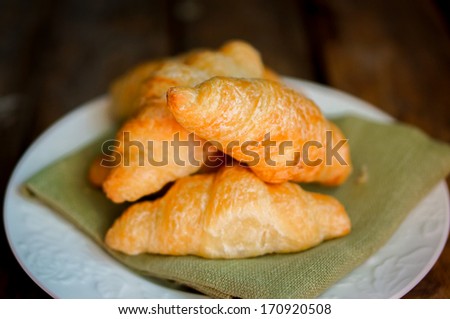 Fresh croissant on wooden background