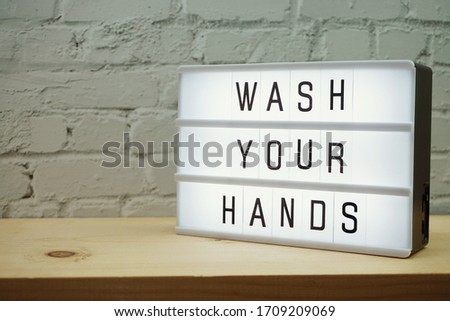 Wash Your Hands word in light box with space coy on white brick and wooden shelves background