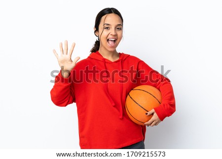 Young woman playing basketball over isolated white background counting five with fingers