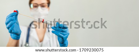 Test for coronavirus Covid-19. Female doctor or nurse doing lab analysis of a nasal swab in a hospital laboratory. Royalty-Free Stock Photo #1709230075