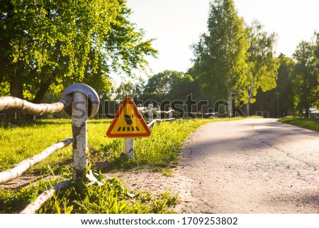Funny and creative road sign "Hedgehog-traveler crosses the road on a pedestrian crossing" in the Park next to the pedestrian path. Eco-Park with a road for trekking and Hiking
