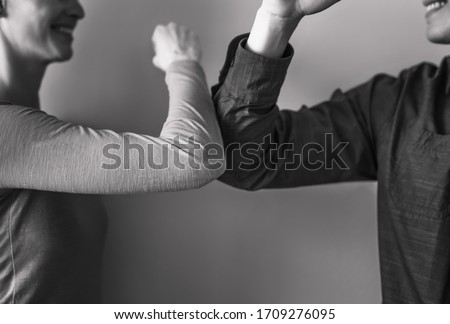 Man woman doing elbow bump greating. New way to say hi without spreading germs.  Royalty-Free Stock Photo #1709276095