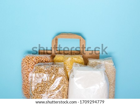 Food for donations. Healthy food on a blue light background. Food delivery in an eco bag. Flat lay style. Copy space for text.