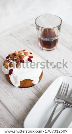 Cake with white cream, almonds and hazelnuts on a dark background. Sweet food. Sweet dessert.