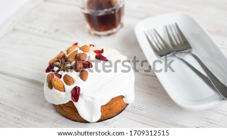 Cake with white cream, almonds and hazelnuts on a dark background. Sweet food. Sweet dessert.