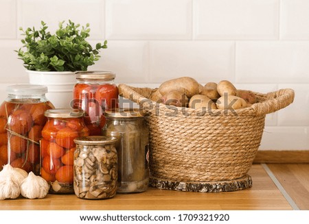 Food supplies crisis food stock for quarantine isolation period.  
potatoes, garlic, canned jars with cucumbers, mushrooms and tomatoes. Food delivery, Donation, coronavirus quarantine. 