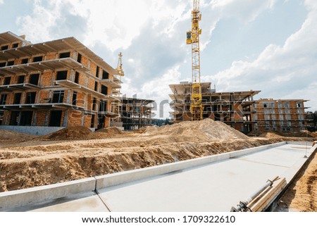  construction site of residential buildings with cranes in sunny weather with blue sky