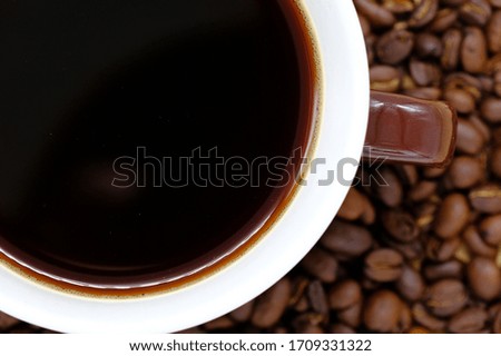 Coffee cup on wooden kitchen table. Top view with morning sunlight
