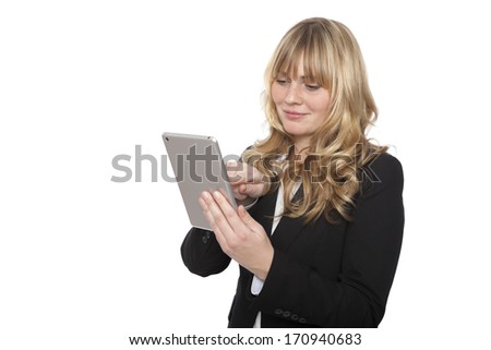 Businesswoman standing surfing the internet on her tablet computer using her fingers on the touchscreen, isolated on white