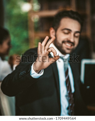 Portrait Of A Businessman Showing Ok Sign, Intelligent Caucasian Man Shows The Okey Gesture Meaning Success And That Everything Will Be Fine, Focus On Male Hand In Foreground, Toned Image