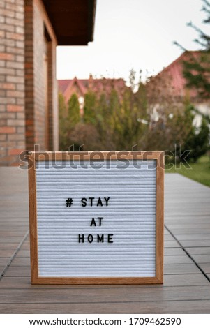 Stay at home' words on a wooden lightbox, standing in the entrance
 to the house door, Copy space. 