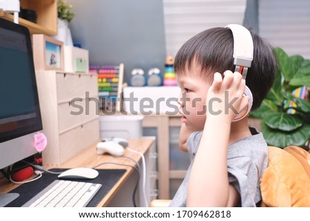 Asian 4 years old toddler boy child using pc computer, Little kid at home, kindergarten closed during the Covid-19 health crisis, Distance Learning, Online Games, Activities for Kindergarten concept