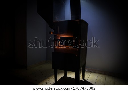 Fire burning in small black iron stove. Traditional Azerbaijani nut stove. Closeup photo with selective focus