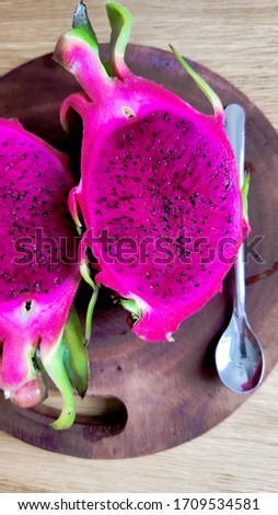Fresh pitahaya fruit sliced on wooden background or ripe dragon fruit red color with copy-space design for drinks package design, healthy article picture and plantation guide book design.