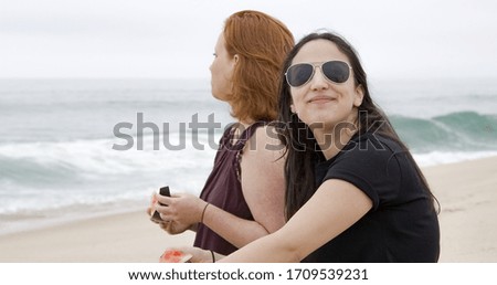 Two girls eat a water melon at the beach - travel photography
