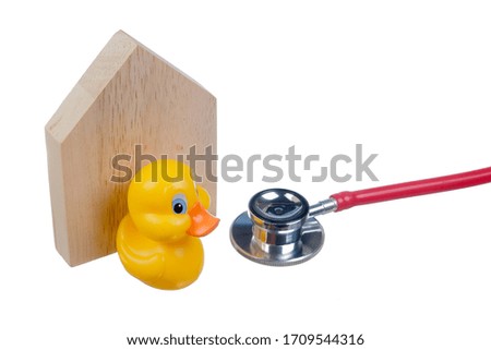 Yellow duck with wooden block house , stethoscope  symbol about  Stay Home  and Stay Safe. Covid-19 Coronavirus Concept.