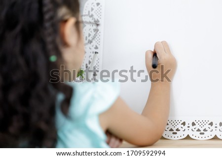 children girl learning to draw with a chemical pen on white paper  