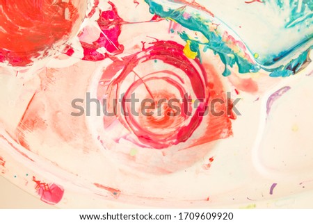 Closeup of stained palette on a white background. Mixing paints. Colorful mix of acrylic vibrant colors.