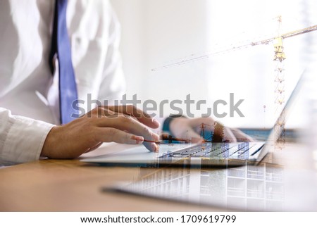 Engineer working with laptop in office and unfinished building, closeup. Double exposure