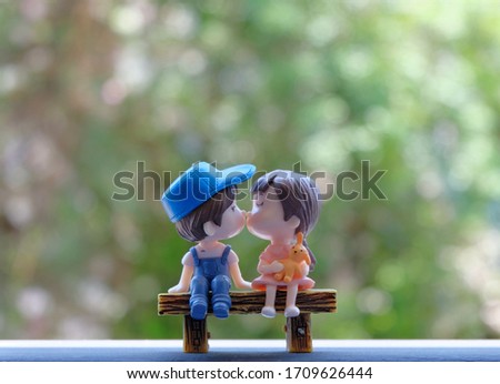 Kissing dolls on a small bench