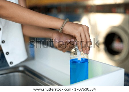 Woman uses disinfectant dispenser to clean his hands.