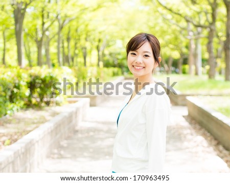 young sporty asian woman relaxing in the park