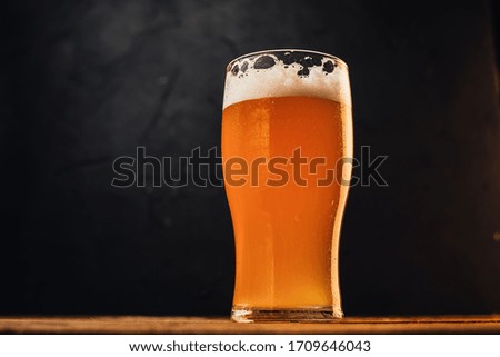 Glass with dark beer on black background