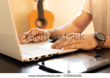 Man remote working with a guitar on the background. Quarantine. Online learning.