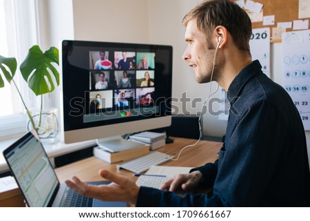 Young man having video call via computer in the home office. Stay at home and work from home concept during Coronavirus pandemic. Virtual house party  Royalty-Free Stock Photo #1709661667