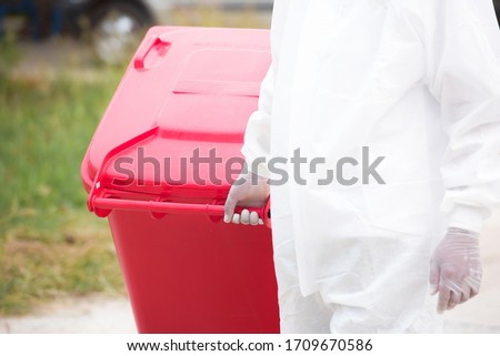 Two Garbagemen work together to empty the trash to get rid of trash during the Kovic-19 disease status.