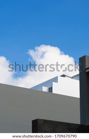 Abstract of part of building with blue sky and cloud. Portrait orientation with copy space.