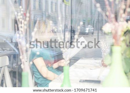 Girl having tea and breakfast in a sunny spring cafe, female hands in the sun rays, meeting friends after quarantine ends due to the coronavirus pandemic