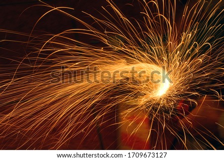 Bright circular sparks background from cutting metal with grinder. 