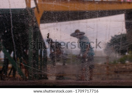 dramatic picture of 2 working Malaysian fishermen taken through an old ruined glass