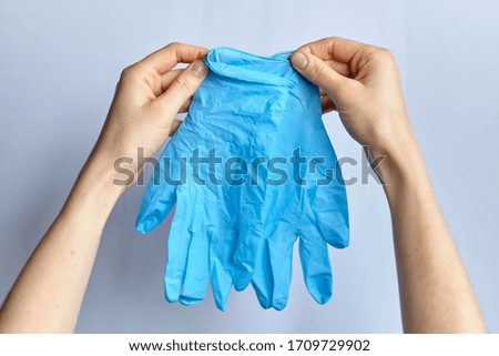 Hand holds medical protective gloves on a white background. Close up.
