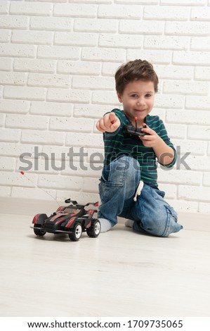 boy with toy car against a brick wall