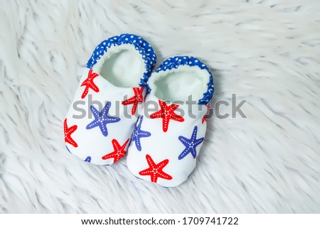 booties for newborns on a white background. lightweight decorative boots for infants up to 1 year old. clothes for babies. small children's shoes made of fabric with rice.