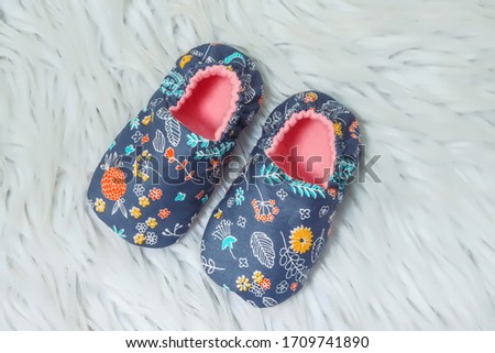 blue booties for newborns on a white background. lightweight decorative boots for infants up to 1 year old. clothes for babies. small children's shoes from fabric with a figure for boys.