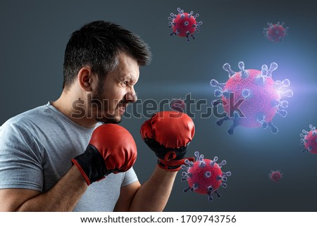 A male boxer in gloves fights with particles of the COVID-19 virus. Concept of pandemic, vaccine