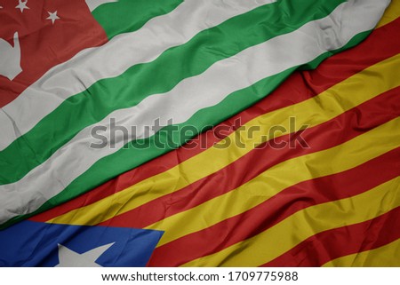 waving colorful flag of catalonia and national flag of abkhazia. macro