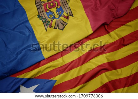 waving colorful flag of catalonia and national flag of moldova. macro
