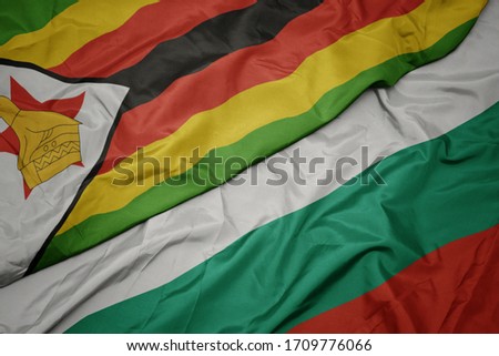 waving colorful flag of bulgaria and national flag of zimbabwe. macro