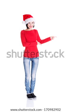 Beautiful smiling christmas santa woman pointing on side showing copyspace. Isolated on white background. 