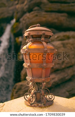 Orange still lantern near waterfall. USA