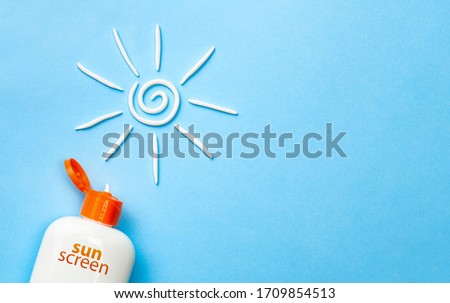 Sunscreen. Cream in the form of sun on blue background with white tube. Copy space for text. Royalty-Free Stock Photo #1709854513
