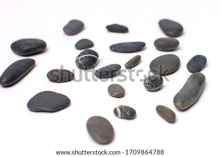 Black sea stones on a white background. Close up.