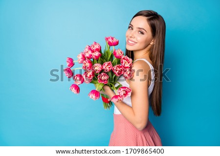 Profile side photo of cute sweet lady girl hold tulips bunch present she get on 8-march 14-february from her boyfriend wear style tank-top isolated over blue color background