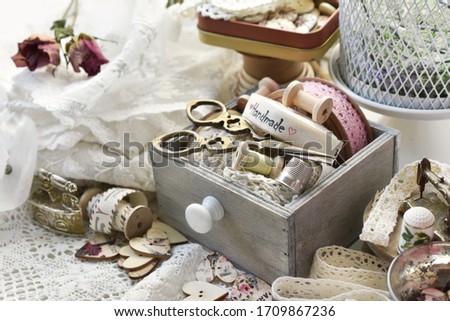 sewing supplies like wooden buttons, lace trims, scissors and ribbons in vintage style Royalty-Free Stock Photo #1709867236